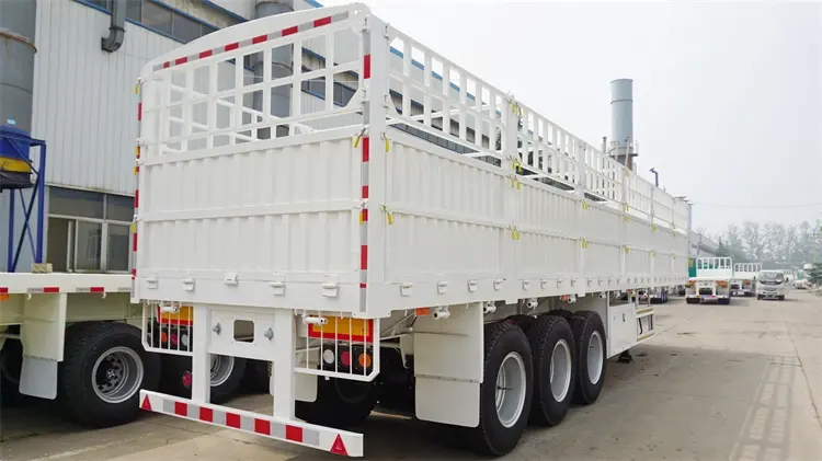 Rear 45-degree view of Kales 60-ton fence semi-trailer with dropsides and steel stakes, ideal for livestock and ventilated agricultural transport.